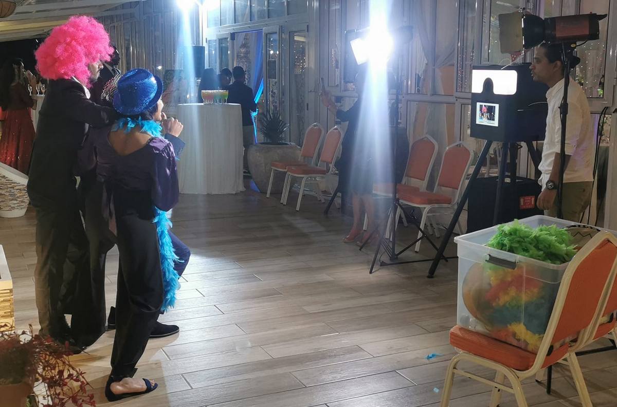 Guests disguised and posing in front of photobooth during wedding